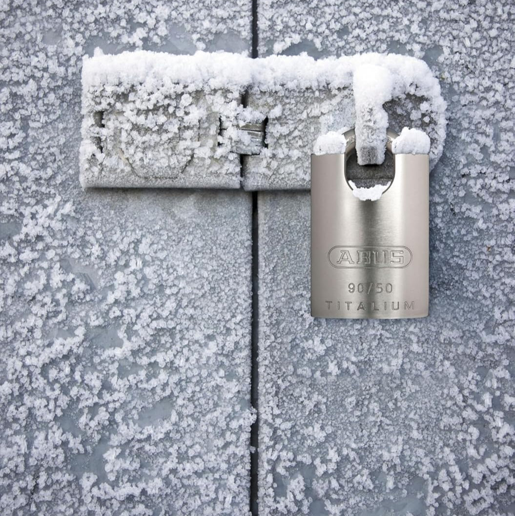 Silver padlock on a frost-covered metal surface